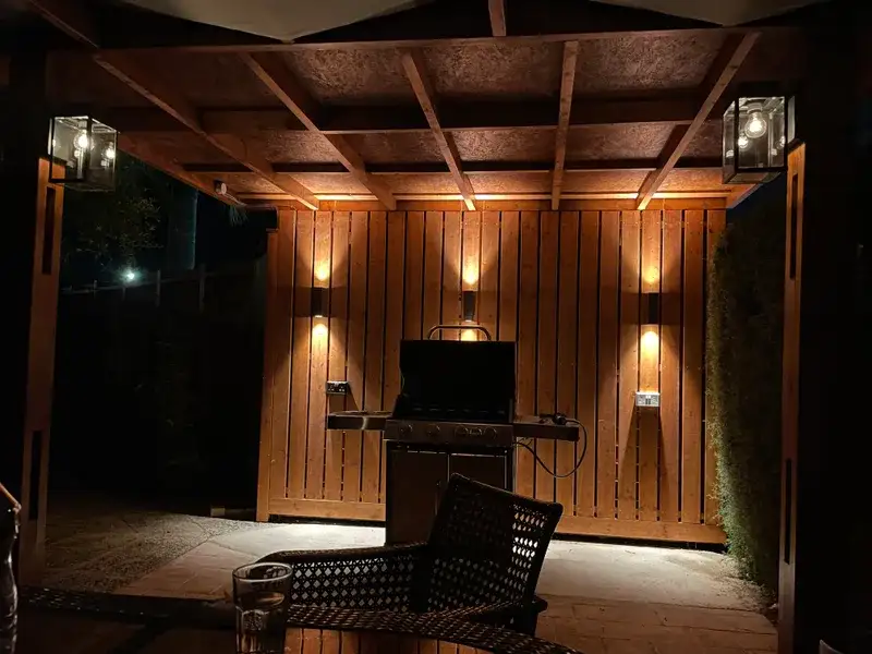 BBQ terrace at night with warm lighting and outdoor furniture